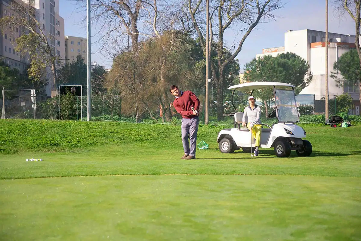 Male Golfer Chipping Golf Balls Onto The Green